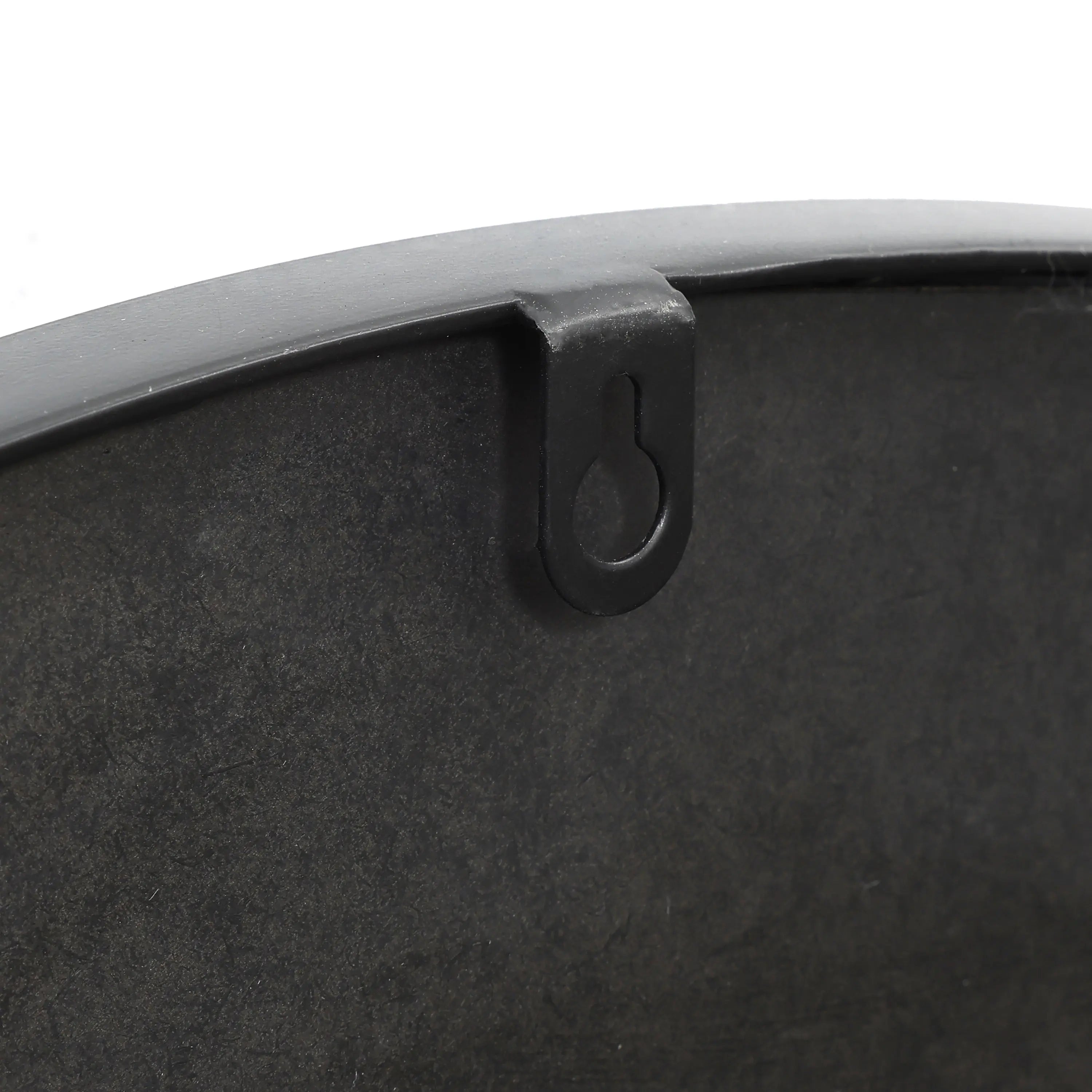 Close-up of a black metal pan with an artistic design, featuring a hanging loop on the side.