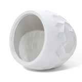 White, textured geometric vase, crafted from durable magnesium oxide material, lays on its side with an open top, showcasing a smooth interior perfect for both indoor and outdoor use.