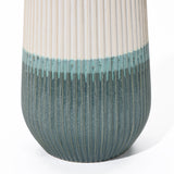 Close-up of a unique ceramic vase with a ribbed texture, transitioning from white at the top to teal at the bottom.