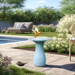 a yellow bird bathing and drinking water in a blue bird bath by the pool