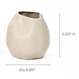 An ivory white, irregularly shaped ceramic vase serves as a charming accent piece with its measurements of 6.69 inches high and 6.89 inches in diameter.