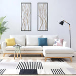 Modern living room with a white sectional sofa, colorful cushions, a floor lamp, a small side table, striking modern wall art as a focal point, a potted plant, and a striped rug on a light wood floor.