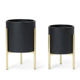 Two black textured planters crafted from durable iron, featuring sleek gold stands, are displayed side by side. This contemporary modern style planter set includes one larger and one smaller pot, adding a touch of elegance to any space.