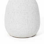 Close-up of a speckled, off-white ceramic vase with a smooth, rounded shape—a charming addition to your home decor reminiscent of a vintage vase.
