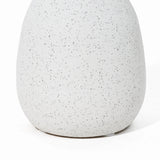Close-up of a speckled, off-white ceramic vase with a smooth, rounded shape—a charming addition to your home decor reminiscent of a vintage vase.