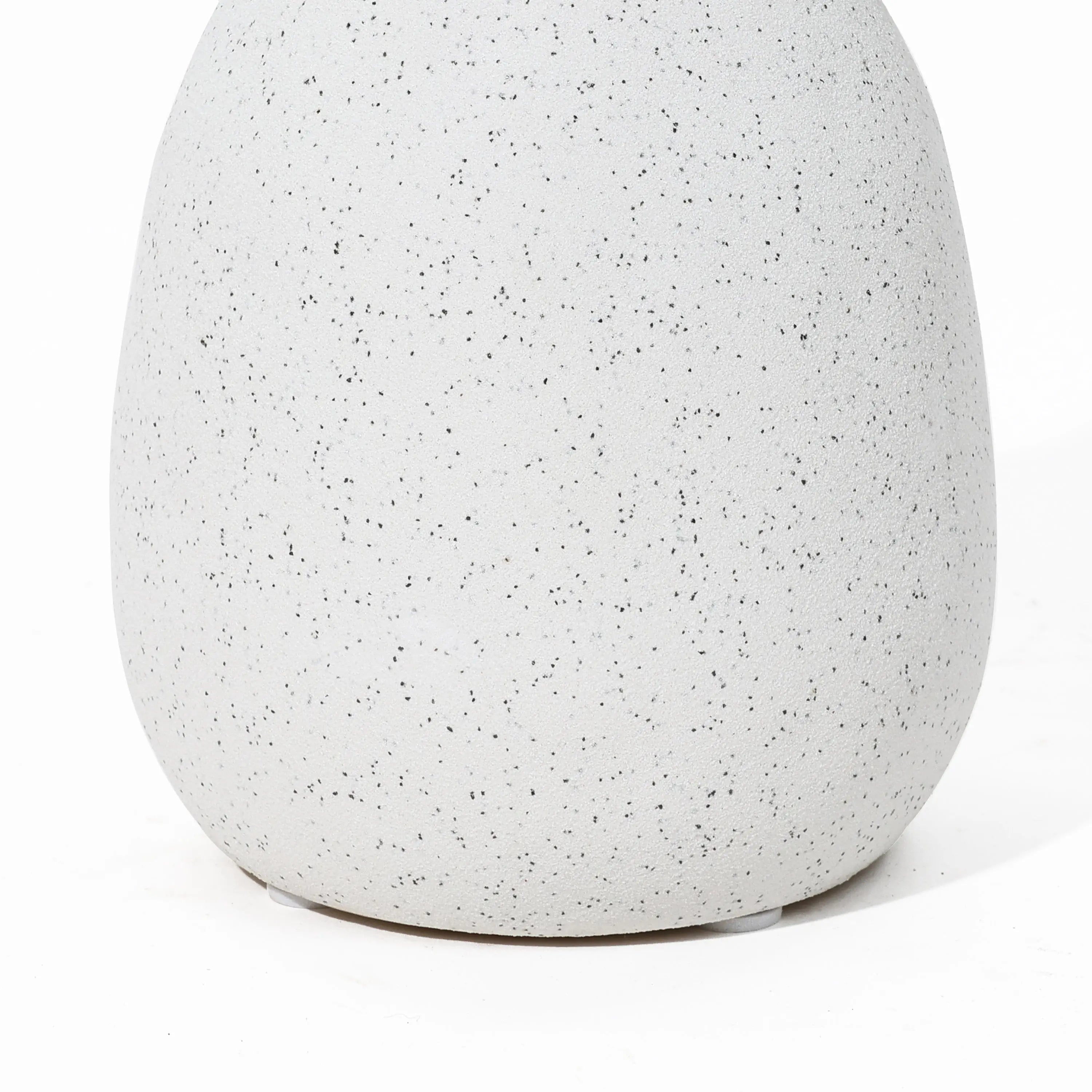 Close-up of a speckled, off-white ceramic vase with a smooth, rounded shape—a charming addition to your home decor reminiscent of a vintage vase.