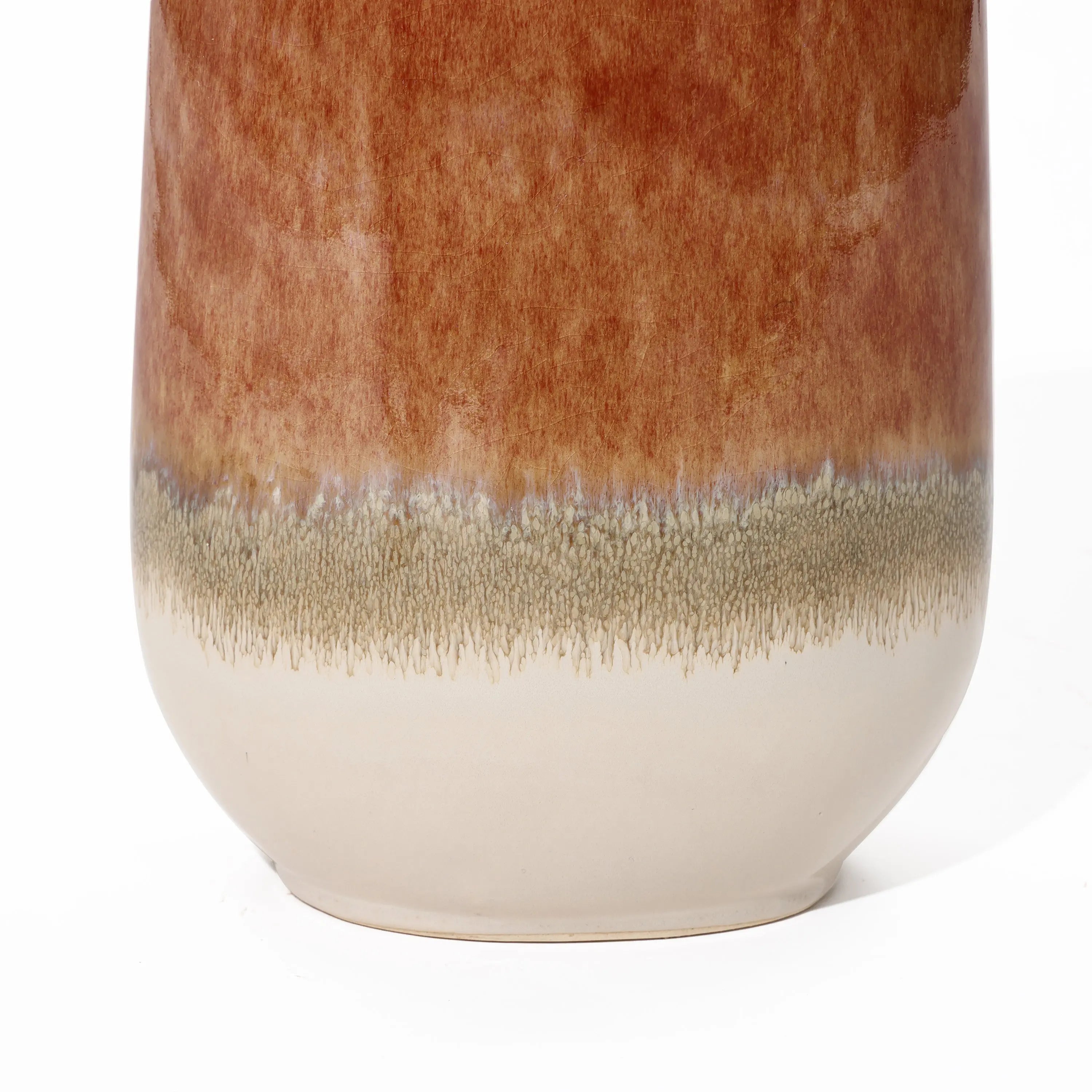Close-up of a vintage ceramic vase featuring a rusty red glaze on the upper portion, seamlessly transitioning into a speckled beige band above its smooth white base, creating a striking color block gradient perfect for any home decor setting.