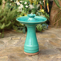 glazed-ceramic-bird-bath-standing-on stone-floor-in-tropical-garden