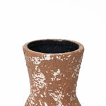 Close-up of the rough textured surface of a tall round ceramic vase with white speckles, exuding rustic charm, showing the upper part and the opening.