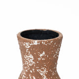 Close-up of the rough textured surface of a tall round ceramic vase with white speckles, exuding rustic charm, showing the upper part and the opening.