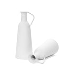 Two white, textured ceramic pitchers, embodying a modern minimalist design; one stands upright while the other lies on its side against a plain background. This elegant table vase set is perfect for enhancing any home decor with understated sophistication.