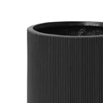 Close-up of the upper half of a black, ribbed cylindrical vase, crafted from magnesium oxide material, featuring a smooth interior.