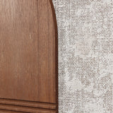 Close-up of a wooden surface with a curved edge paired elegantly with textured, woven fabric, reminiscent of abstract wall art.