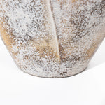 Close-up of a textured, weathered ceramic vase featuring a speckled pattern reminiscent of a broken egg design in shades of gray and brown.