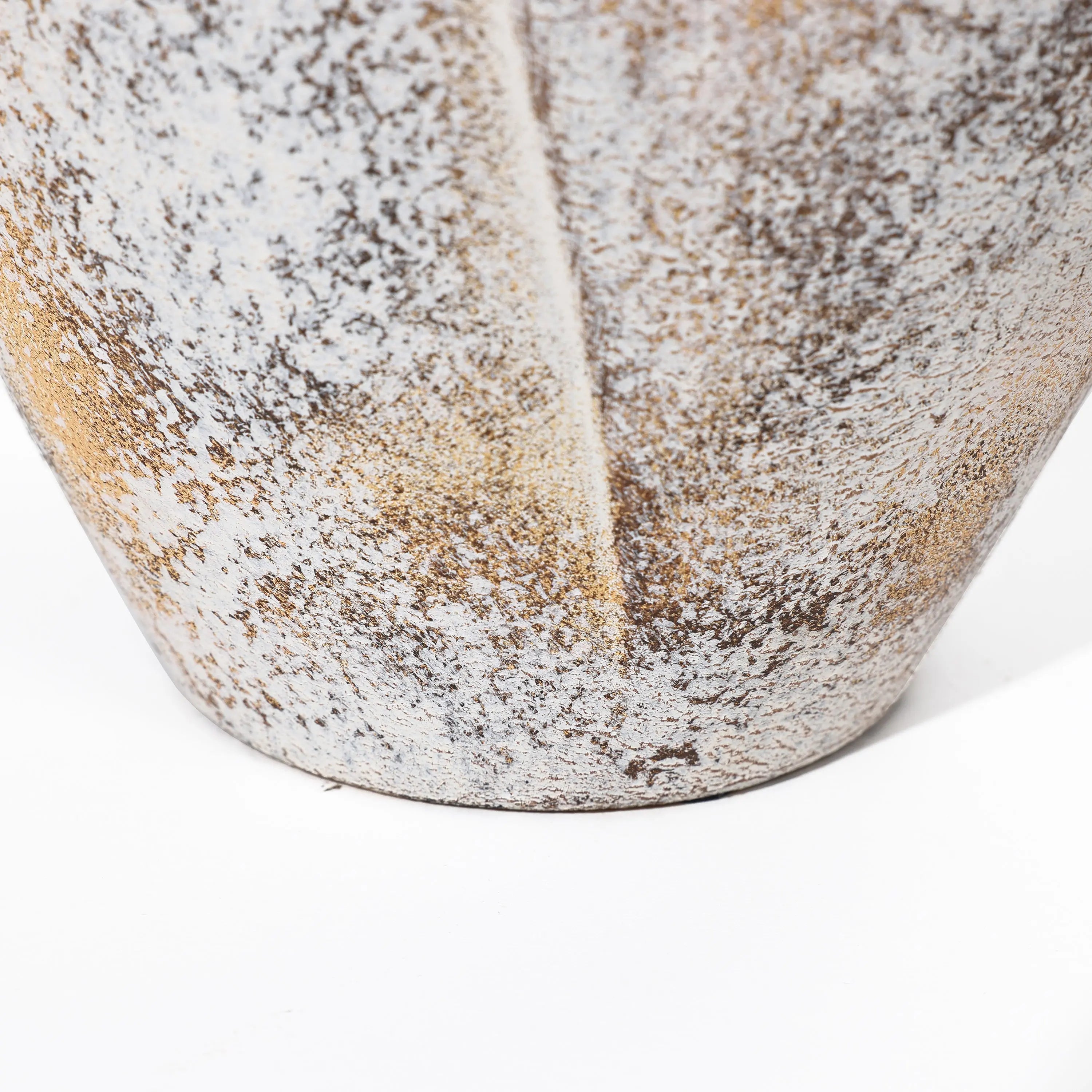 Close-up of a textured, weathered ceramic vase featuring a speckled pattern reminiscent of a broken egg design in shades of gray and brown.