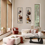 Modern living room with a cream sofa, glass coffee table, red accent chair, and modern wall decor featuring two abstract pieces on a beige wall beside large windows showcasing trees outside.