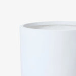 Close-up view of the top edge of a smooth, white cylindrical container with a minimalist design against a plain background.