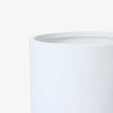 Close-up view of the top edge of a smooth, white cylindrical container with a minimalist design against a plain background.