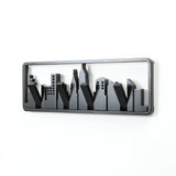 A black metal wall hook designed like a city skyline silhouette features flip-down hooks for added functionality.