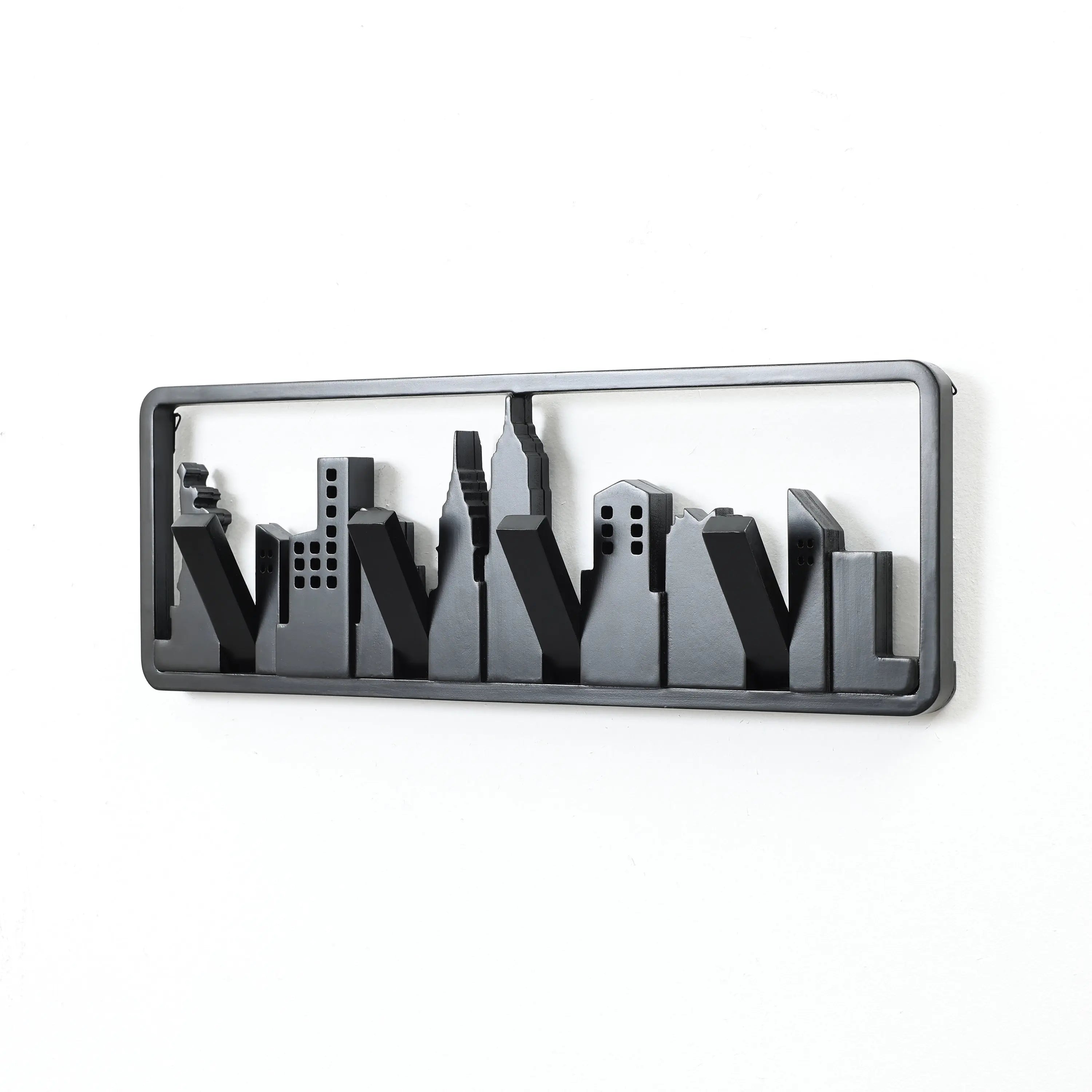 A black metal wall hook designed like a city skyline silhouette features flip-down hooks for added functionality.